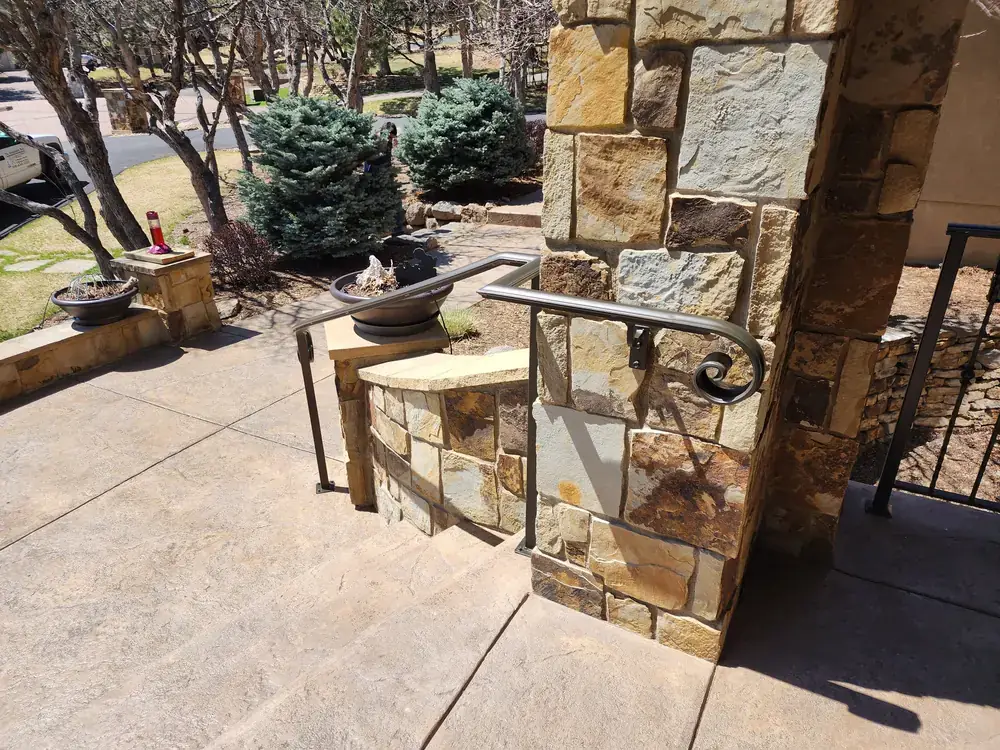Rustic iron railing on stone patio